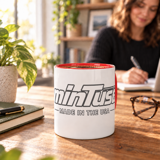 Red-accent minTusa Signature mug on a warm home-office desk