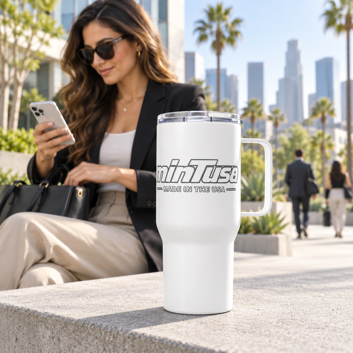 White minTusa Signature travel mug in a bright Los Angeles commuter plaza