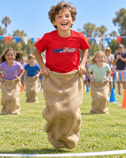 Boy wearing a red minTusa Star Spangled Youth T-Shirt while leading a school field-day sack race